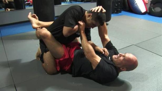 Hur ansöker en triangel choke från öppen guard i mixed martial arts. Börja med att lägga på rygg med benen isär.